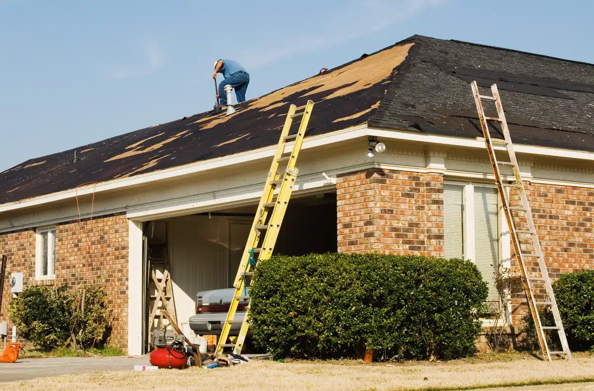 roof replacement process of the brick house and worker on the roof