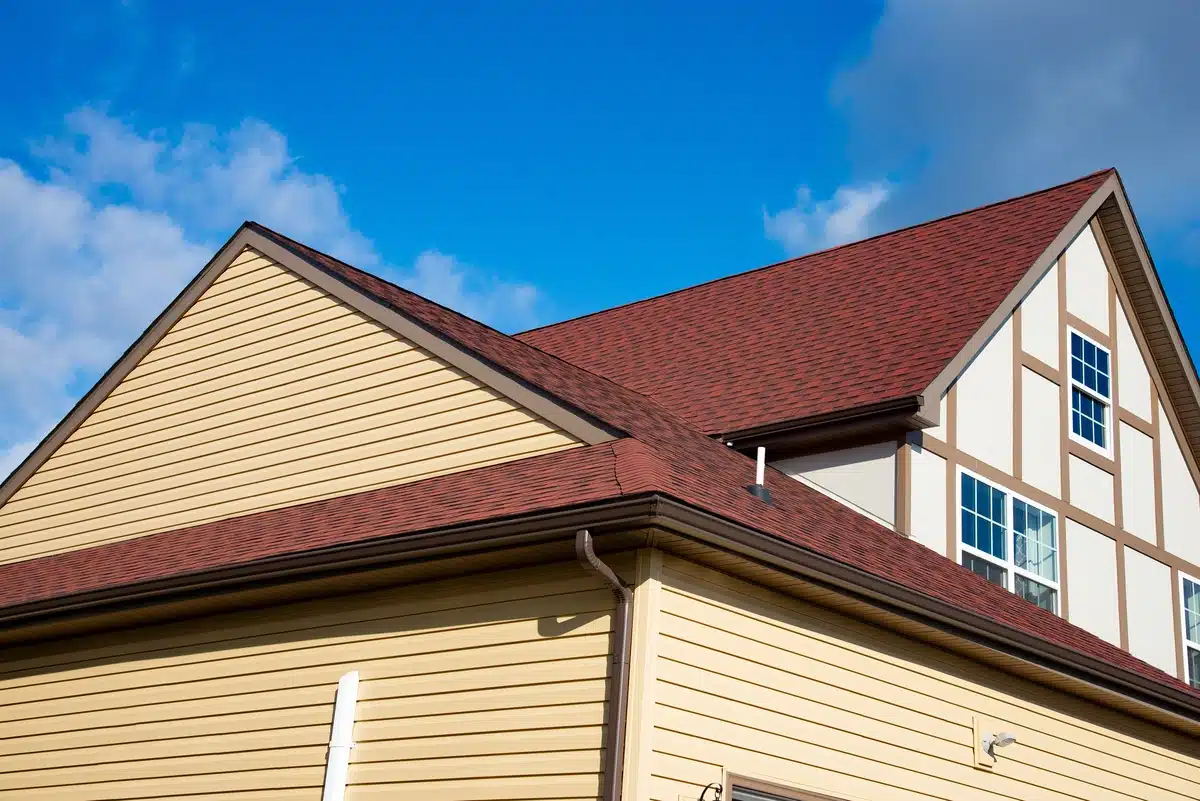 vinyl siding house with red asphalt shingle roof