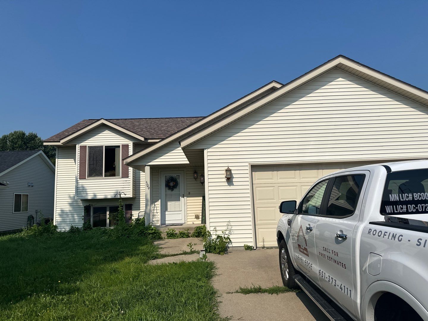 Finished shingle roof on a light-sided split-level home with an attached garage